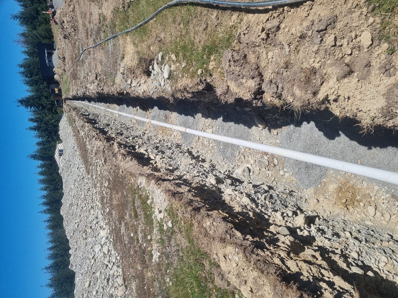 New water line laid in a trench across rural ground