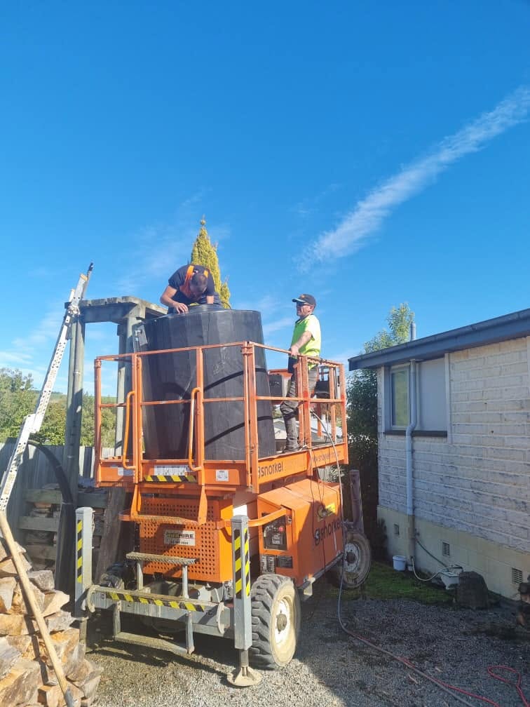 Installing a new water tank from a scissor lift